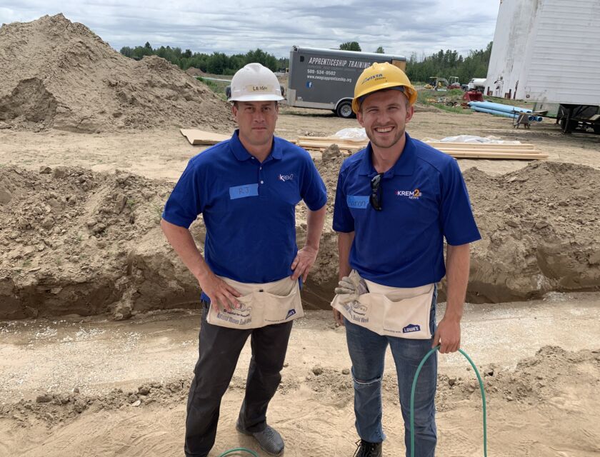 Two male KREM volunteers outside