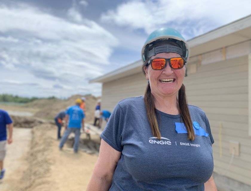 Engie Insight volunteer next to house