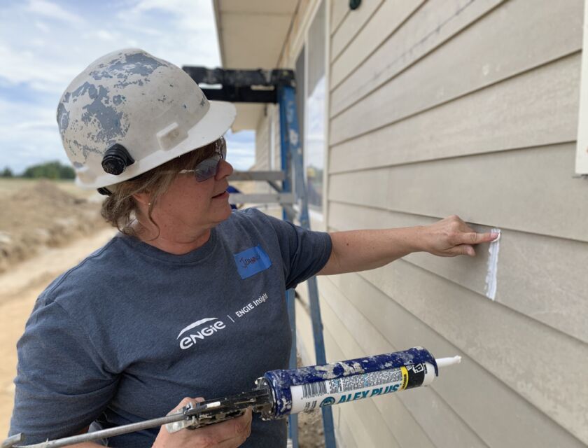 Female volunteer using calking gun
